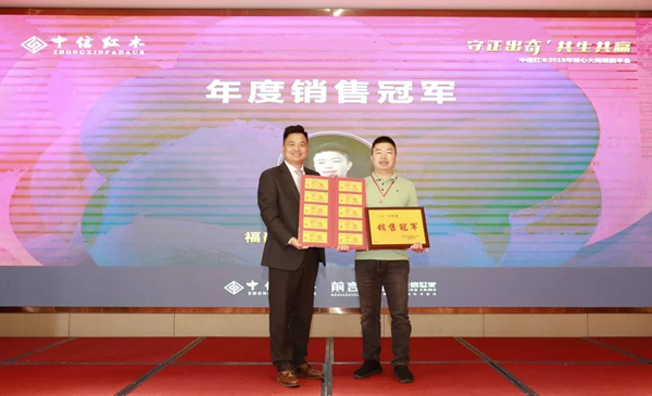 浙江省工艺美术大师、浙江中信红木董事长李忠信（左）为2018年度销售冠军颁奖